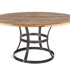 May include: A round wooden table with a natural wood finish and a black metal base. The table has a simple, rustic design.