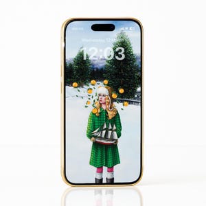 Puede incluir: Un smartphone dorado muestra una ilustración caprichosa. La obra presenta a una persona con abrigo y sombrero verdes sosteniendo un barco, con naranjas y un paisaje nevado de fondo. La hora es 12:03 el miércoles 12 de marzo.