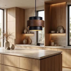 Peut inclure: Une suspension cylindrique composée de deux bandes texturées noir mat et d'une bande centrale en bois foncé lisse. Le luminaire est suspendu par un fin cordon noir et diffuse une lumière chaude depuis la partie inférieure ouverte.