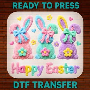 May include: A colorful Easter-themed design featuring three textured bunny figures in pink, teal, and purple, each with a bow and flower. The words "Happy Easter" are displayed below, with "READY TO PRESS" and "DTF TRANSFER" above and below.