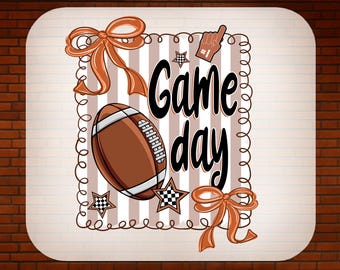 May include: A DTF transfer design with a football, stars, and bows, with the words "Game Day" in a script font. The design includes a foam finger and the words "Ready to Press". The background has vertical stripes.