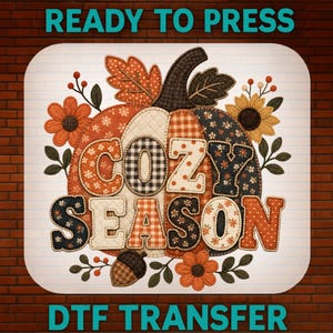 Peut inclure: Un transfert DTF représentant une grande citrouille avec une texture matelassée et divers motifs, notamment des carreaux, des pois et des imprimés floraux. Le texte COZY SEASON est superposé en grandes lettres. Entouré de feuilles, fleurs et un gland.