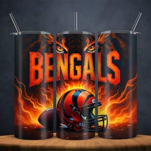 Pu&ograve; includere: Tre bicchieri in acciaio inossidabile neri con la scritta "BENGALS" in arancione, un casco da football e un pallone da football. Il design include una faccia di tigre e fiamme. Ogni bicchiere ha un coperchio argentato e una cannuccia.
