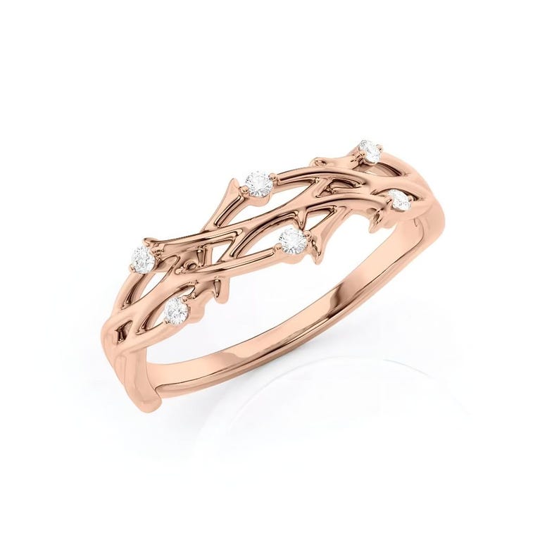 Puede incluir: Anillo de oro rosa con un delicado dise&ntilde;o de vid, adornado con peque&ntilde;os diamantes brillantes. Las intrincadas ramas del anillo crean una est&eacute;tica elegante inspirada en la naturaleza. Una hermosa pieza de joyer&iacute;a.