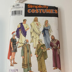 Puede incluir: Un sobre de patrón de costura Simplicity Costumes con ilustraciones de siete atuendos históricos y bíblicos. El paquete muestra varias túnicas, vestidos y un disfraz de soldado romano con capa roja, junto al texto Andrea Schewe.