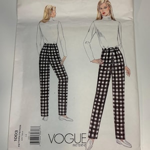 May include: A Vogue Patterns sewing pattern envelope, number 1003, size 14. The illustration shows a white turtleneck long-sleeve top paired with high-waisted, black and white gingham check trousers. The design features a front button closure.