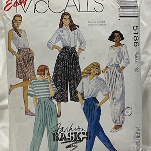 May include: A vintage McCall's sewing pattern titled "Fashion Basics." The pattern features illustrations of various women's clothing designs, including skirts, pants, and tops. The pattern number is 5186, size 12. The cover is white with red and black text.