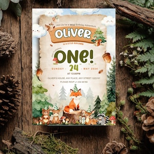 Puede incluir: Una tarjeta de invitación de cumpleaños con un tema de bosque en acuarela, que incluye un zorro, un oso, un ciervo y un mapache con gorros de fiesta. El texto dice: Join Us for a Wild Birthday Adventure, OLIVER, IS A LITTLE EXPLORER, AND TURNING ONE!.