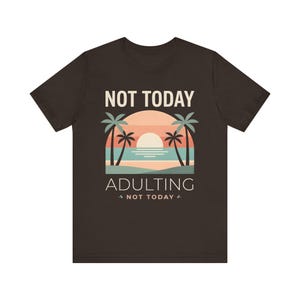 May include: A dark brown short-sleeved t-shirt featuring a graphic of a sunset over the ocean with palm trees. The text "NOT TODAY" appears above the graphic, and "ADULTING" with "NOT TODAY" below it in a clean, sans-serif font style.