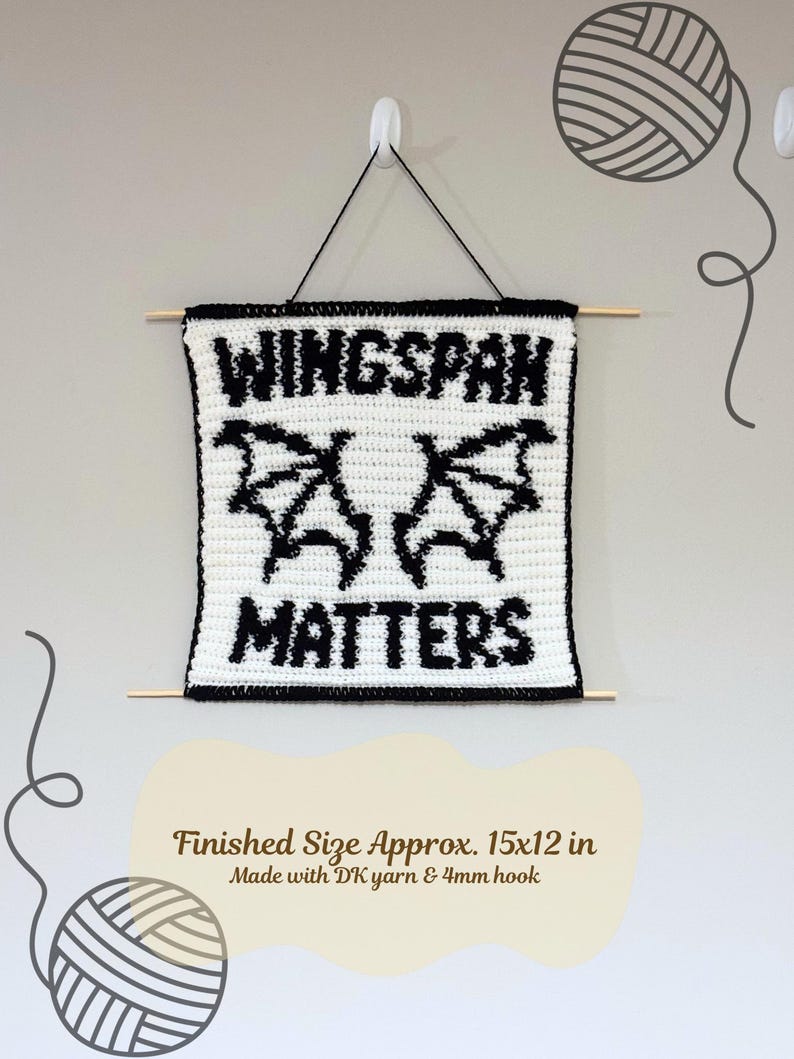 K&ouml;nnte beinhalten: Geh&auml;keltes Wandbild mit dem Text "WINGSPAN MATTERS" in Schwarz auf Wei&szlig;, mit fledermausartigen Fl&uuml;geln. Fertige Gr&ouml;&szlig;e ca. 38x30 cm. Aufgeh&auml;ngt mit schwarzem Faden und Holzst&auml;ben, ein einzigartiges Wohnaccessoire.