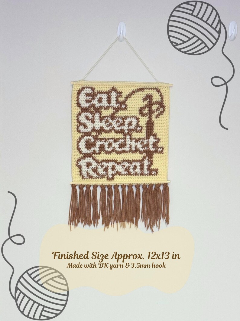 May include: A crocheted wall hanging with the words "Eat, Sleep, Crochet, Repeat" in brown and white. The finished size is approximately 12x13 inches. It has a fringe at the bottom and is suspended by a string.