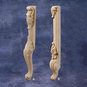 Puede incluir: Dos patas de mueble de madera tallada sin terminar. La pata A presenta un diseño curvo con detalles ornamentados de hojas y volutas. La pata B tiene un diseño similar, con una disposición ligeramente diferente de los elementos decorativos. Ambas patas están sin pintar y listas para el acabado.