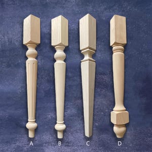 Puede incluir: Cuatro patas de muebles de madera sin terminar en varios diseños. Las patas son de color claro, con veta de madera natural. Cada pata tiene una forma diferente, incluyendo estilos estriados, torneados y cónicos. Las patas están etiquetadas A, B, C y D.