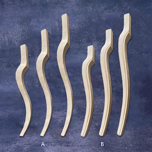 May include: Six unfinished wooden furniture legs with a curved, serpentine design. The legs are of varying heights, with a natural wood grain finish. The background is a dark blue-green color. The legs are labeled A and B.
