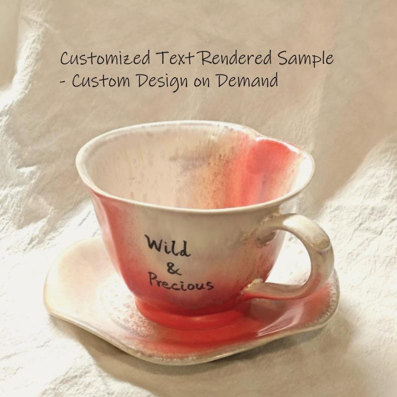 May include: A ceramic teacup and saucer set with a heart-shaped design. The cup and saucer are primarily white with red accents and the words "Wild & Precious" on the cup. The image also includes the text "Customized Text Rendered Sample - Custom Design on Demand."
