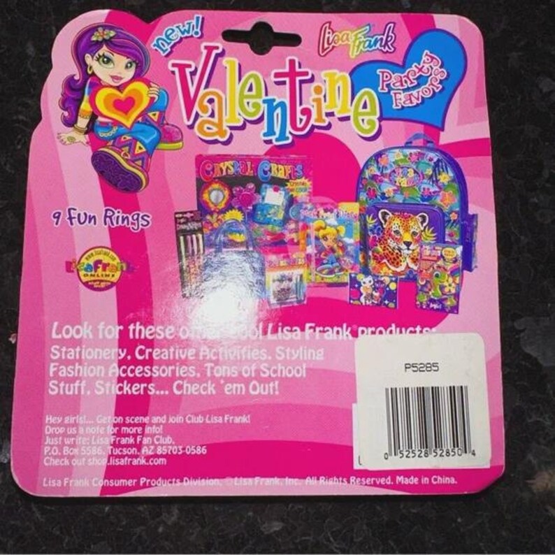 May include: A pink Lisa Frank Valentine's Day package with a cartoon girl holding a heart. The package includes a backpack, stationery, and stickers. Text includes "9 Fun Rings" and "Lisa Frank".