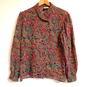 May include: A long-sleeved button-up shirt with a paisley pattern in shades of red, green, blue, and black.
