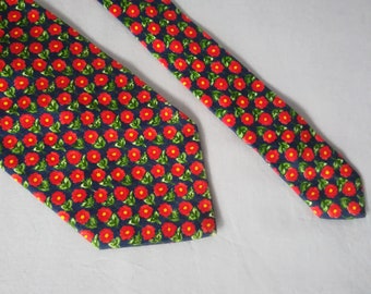 May include: A dark blue necktie with a repeating pattern of red flowers on green leaves.