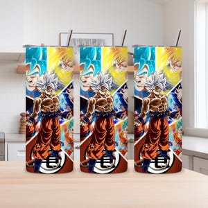 May include: Three stainless steel tumblers with a colorful anime-style design. Each tumbler features a central image of a muscular character in orange and blue attire, with a silver straw. The background is a collage of character images.