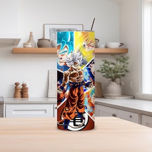 May include: A stainless steel tumbler featuring a collage of anime characters in various forms and colors. The design includes a central figure in orange pants and a white top, with other characters in blue and yellow. A silver straw is inserted in the lid.
