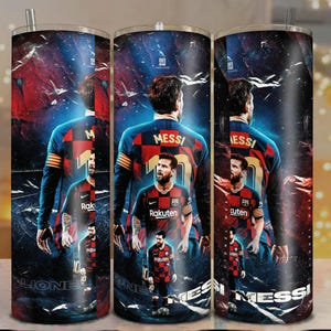 Puede incluir: Un vaso de acero inoxidable con un dise&ntilde;o de un jugador de f&uacute;tbol con una camiseta roja y azul. El vaso tiene un fondo negro con el nombre del jugador y la palabra "MESS" impresa. El vaso tiene una pajita plateada.