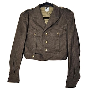 May include: A brown wool jacket with gold buttons and four front pockets. The jacket has a notched collar and epaulets. The jacket is hanging on a black hanger. The tag on the hanger reads "24".