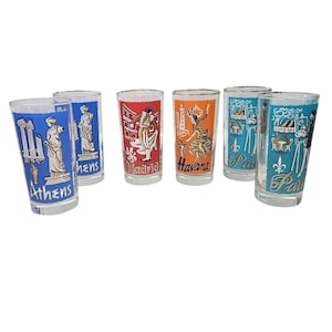 May include: Set of six vintage travel-themed drinking glasses. Each glass features a different city: Athens, Madrid, Havana, and Paris. The glasses have colorful illustrations and city names, with a clear glass base and a silver rim.