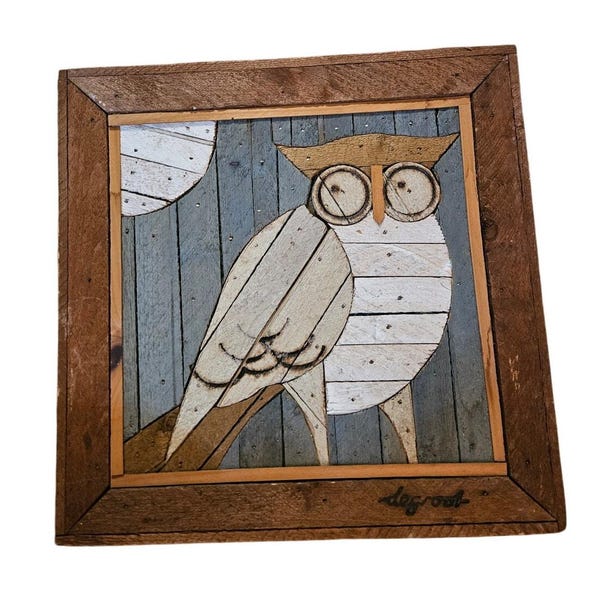 Peut inclure: Une œuvre d'art murale carrée en bois représentant une mosaïque de hibou sur un fond de planches verticales bleu-gris avec une lune blanche. Le hibou est composé de lattes de bois clair. Le nom degroot est écrit dans le coin inférieur droit.