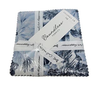 May include: A stack of blue and white fabric squares with a floral pattern, wrapped with a white ribbon that reads "Cut out for happiness." A tag with the words "Boundless Fabrics" is attached.