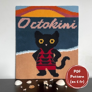 Peut inclure: Tapisserie faite à la main avec un chat noir en maillot de bain rouge sur une plage. Le mot "Octokini" est au-dessus. Le fond montre un coucher de soleil. La tapisserie est un patron PDF, en anglais et en français.