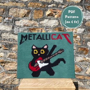 May include: A teal-colored, square textile art piece featuring a black cat playing a red guitar. The word "METALLICAT" is displayed in black and red letters. A green circle with the text "PDF Pattern (en & fr)" is in the upper right corner.