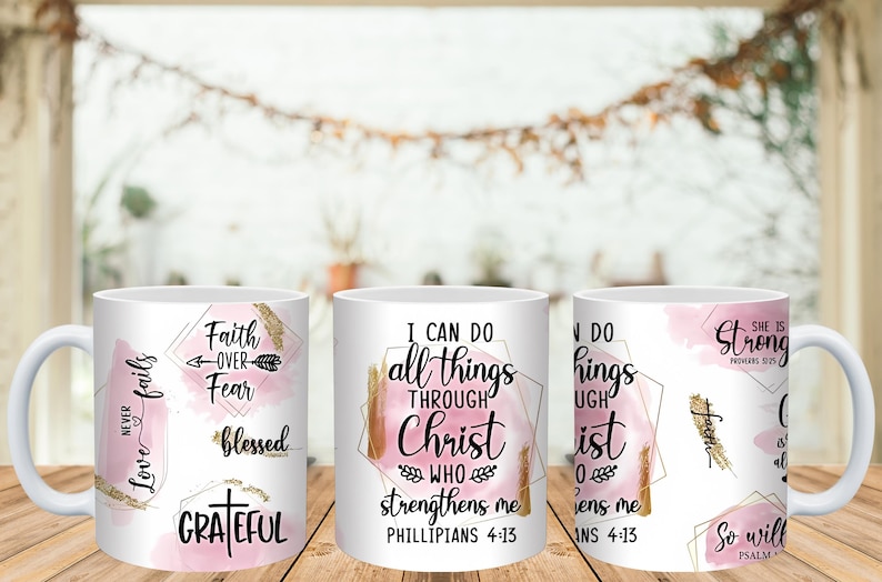 May include: White ceramic mugs with inspirational quotes and phrases in black script and gold accents. The mugs feature pink watercolor backgrounds and geometric shapes. Phrases include "Faith Over Fear" and "I Can Do All Things Through Christ."