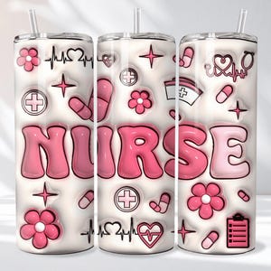 May include: A white tumbler with a pink and white design. The word "NURSE" is in large pink bubble letters. The tumbler is decorated with pink flowers, pills, crosses, stars, and a heartbeat symbol.