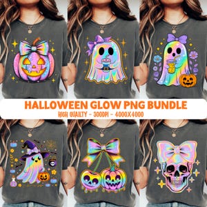 May include: A collection of six charcoal gray t-shirts featuring iridescent Halloween graphics including a pumpkin with a bow, a ghost holding a drink, a ghost with flowers and a pumpkin, a witch ghost, cherry-shaped skulls, and a skull with a bow.