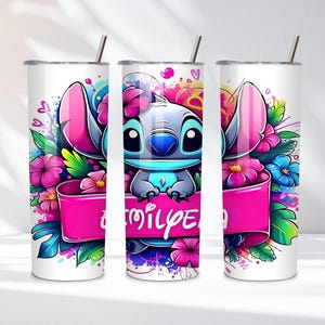 K&ouml;nnte beinhalten: Ein wei&szlig;er Becher mit einer farbenfrohen Illustration der Figur Stitch, umgeben von rosa und blauen Blumen. Ein rosa Banner mit dem Wort "family" ist zu sehen. Der Becher hat einen silbernen Strohhalm.