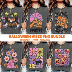 May include: A collection of six charcoal gray t-shirts featuring various Halloween-themed graphic prints including skeletons, ghosts, flowers with jack-o'-lantern faces, bats, and strawberries with text such as Spooky Things Ahead and Spooky Season.