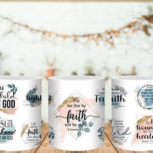 May include: Three white ceramic mugs with inspirational quotes and watercolor designs. The mugs feature phrases like "I am a Child of God" and "For we live by faith." The designs include gold foil accents and pastel colors.