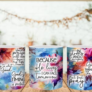 May include: Three white ceramic mugs with colorful floral designs and inspirational quotes. The mugs feature text like "Cling to what is Good" and "Because He lives I can face tomorrow."