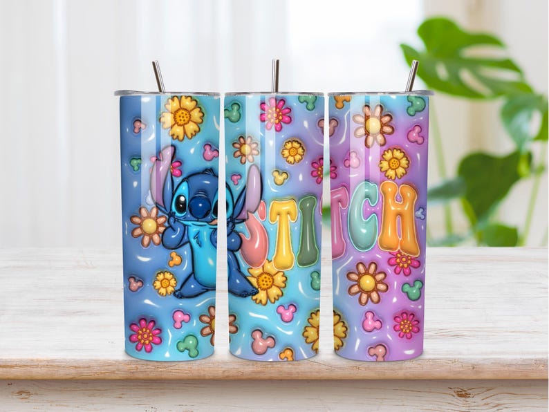 May include: A cylindrical metal tumbler with a straw, featuring a blue and purple gradient background decorated with yellow and pink flowers, small mouse-ear silhouettes, and a blue alien character next to the colorful text STITCH in bubble letters.