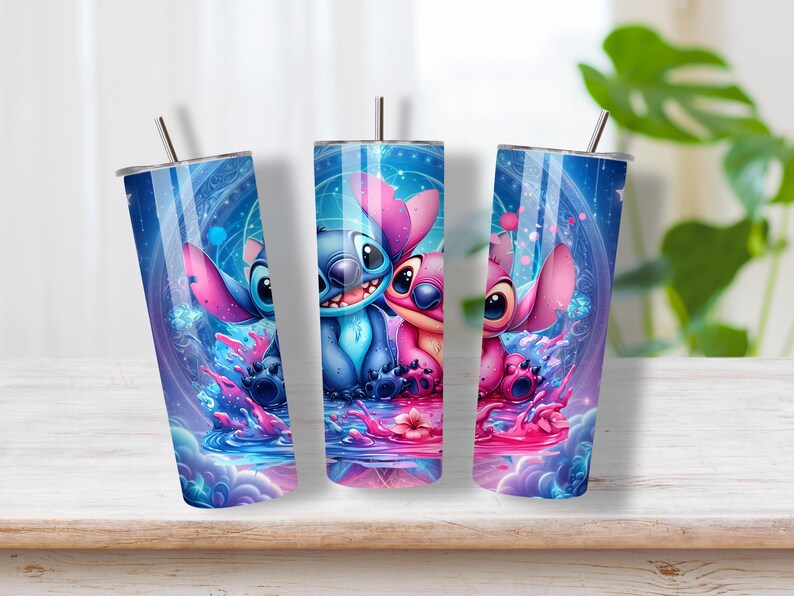 Puede incluir: Tres vasos cil&iacute;ndricos con pajitas de metal que presentan un estampado gr&aacute;fico vibrante de personajes alien&iacute;genas azules y rosas sentados en el agua. El dise&ntilde;o incluye patrones c&oacute;smicos, efectos de luz brillantes y una peque&ntilde;a flor.