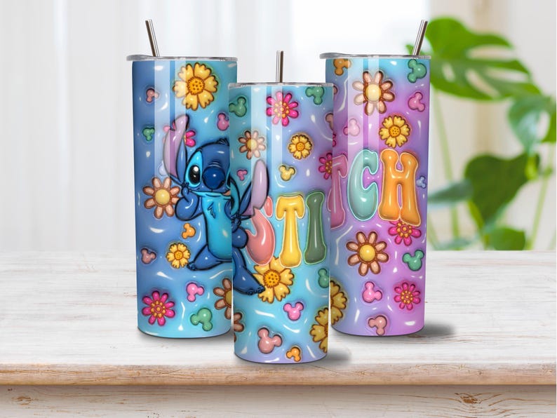 May include: Three cylindrical tumblers with metal straws featuring a blue and purple gradient background. The design includes a blue character, yellow and pink flowers, small mouse-ear shapes, and the word STITCH in large, colorful bubble letters.