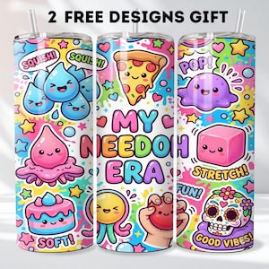 Peut inclure: Trois gobelets cylindriques avec pailles présentant un motif coloré de personnages de dessins animés, de nourriture et de formes. Le texte MY NEEDOH ERA est imprimé au centre. On y voit aussi SQUISH, POP, STRETCH, FUN, SOFT et GOOD VIBES.