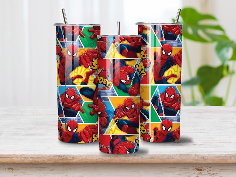 以下が含まれることがあります： 赤と青のスパイダーマンのグラフィックプリントが繰り返された3つの円筒形メタルタンブラー。各タンブラーには金属製のストローと蓋が付いており、黄色、緑、青の背景にコミックブック風のパネルがデザインされています。