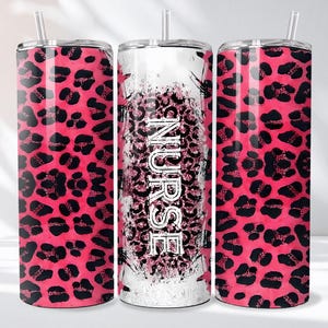 May include: Three stainless steel tumblers with lids and straws. Two tumblers feature a pink leopard print pattern. The center tumbler has the word "NURSE" in white, with a pink leopard print background.