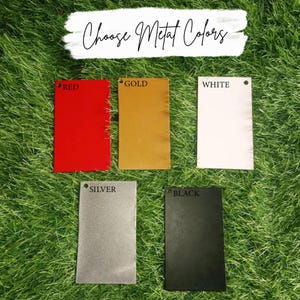 May include: Five metal color samples: red, gold, white, silver, and black. Each sample is a rectangular shape with a small hole at the top. The text "Choose Metal Colors" is written in cursive above the samples.