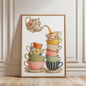 Op de afbeelding: Een ingelijste muurkunstprint met een bloemrijke theepot die thee schenkt in een stapel kleurrijke theekopjes. De illustratie toont diverse patronen, waaronder bloemen, strepen en effen kleuren zoals roze, geel, groen, oranje en blauw.