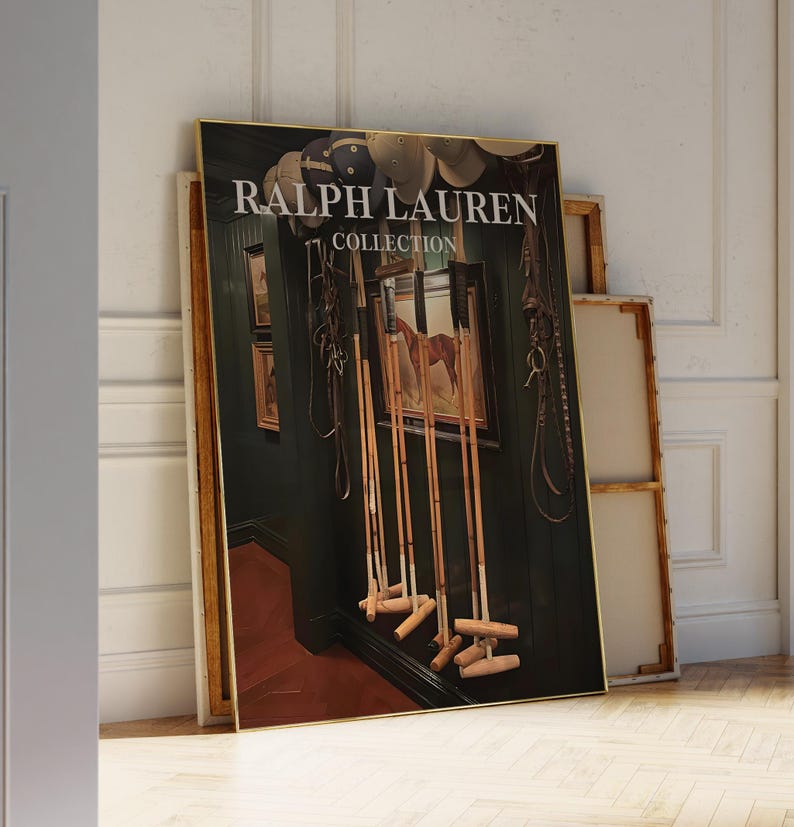 Op de afbeelding: Een ingelijste print van de Ralph Lauren Collection met een paardenschilderij, polomallen en paardensportuitrusting. De print heeft een gouden lijst en staat tegen een muur. De tekst "RALPH LAUREN COLLECTION" is zichtbaar.