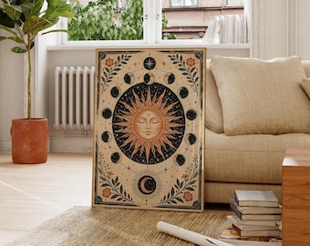 May include: A rectangular wall art print featuring a central sun face with rays surrounded by a circular lunar phase cycle. The design includes botanical leaf and flower motifs in the corners, set against a cream background with black ink details.