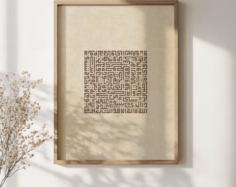 May include: A framed print featuring intricate Arabic calligraphy in brown ink on a beige background. The artwork is displayed in a light brown wooden frame. The image is set against a white wall, with a vase of dried flowers and a coffee cup on a wooden table.