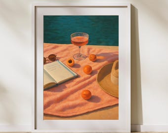 Könnte beinhalten: Gerahmter Kunstdruck mit einer sommerlichen Szene. Ein Glas rosa Getränk, Sonnenbrille, Strohhut und ein Buch liegen auf einem pfirsichfarbenen Handtuch. Mehrere Orangen sind verstreut. Im Hintergrund ist ein Pool zu sehen.